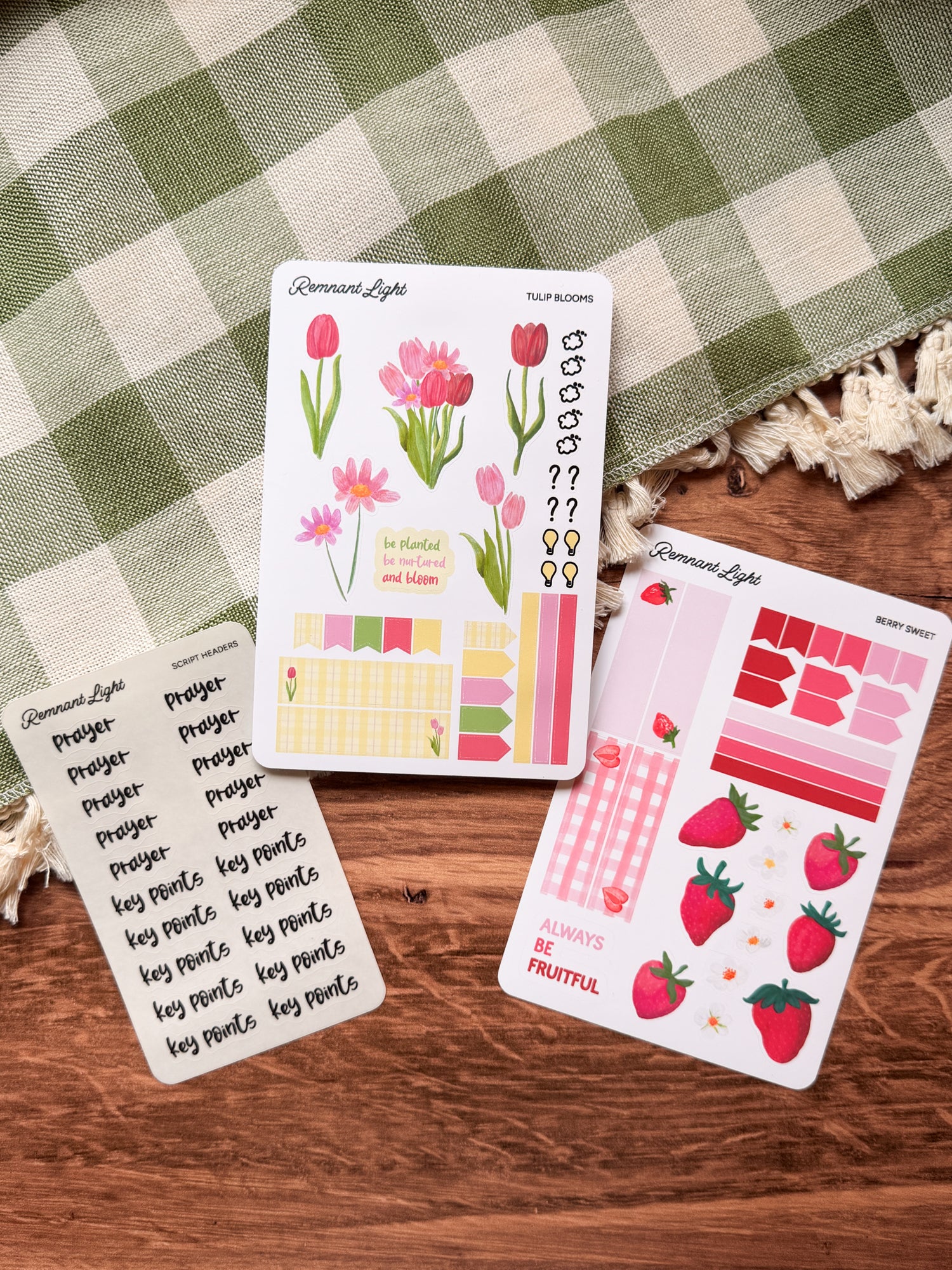 Set of decorative planner stickers on a wooden surface with a checkered cloth background