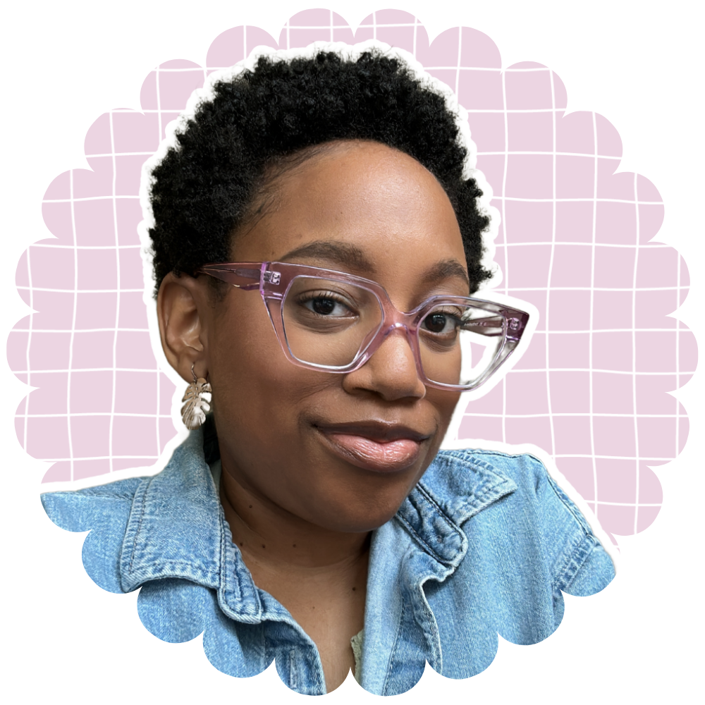 Jasmine wearing clear purple glasses and a denim shirt with a decorative pink background
